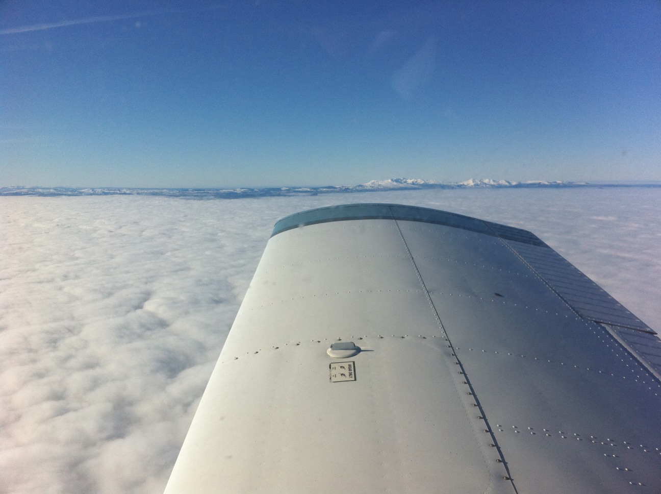 Le PA28 Arrow F-BRUE au-dessus des nuages avec les Alpes en arrière-plan